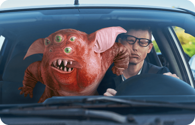 Creature elbowing a man who is driving in the face