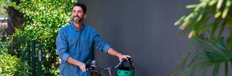 Smiling man walking next to a bicycle